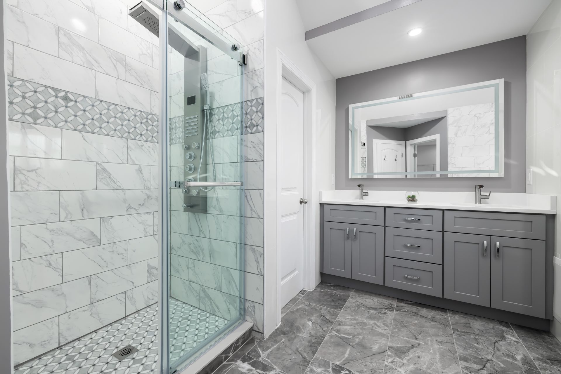 Bathroom with a glass walk-in shower and a gray double vanity